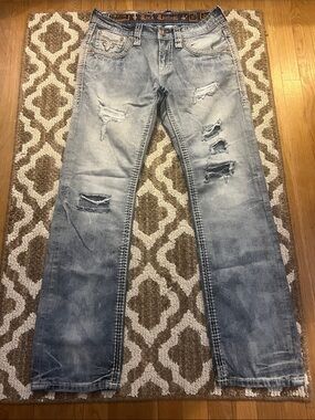Rock Revival Men’s Faded Light Blue Straight Jeans with Distressed Rips